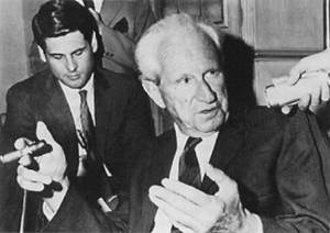 Herbert, with cigar, speaking to reporters in the 1960s